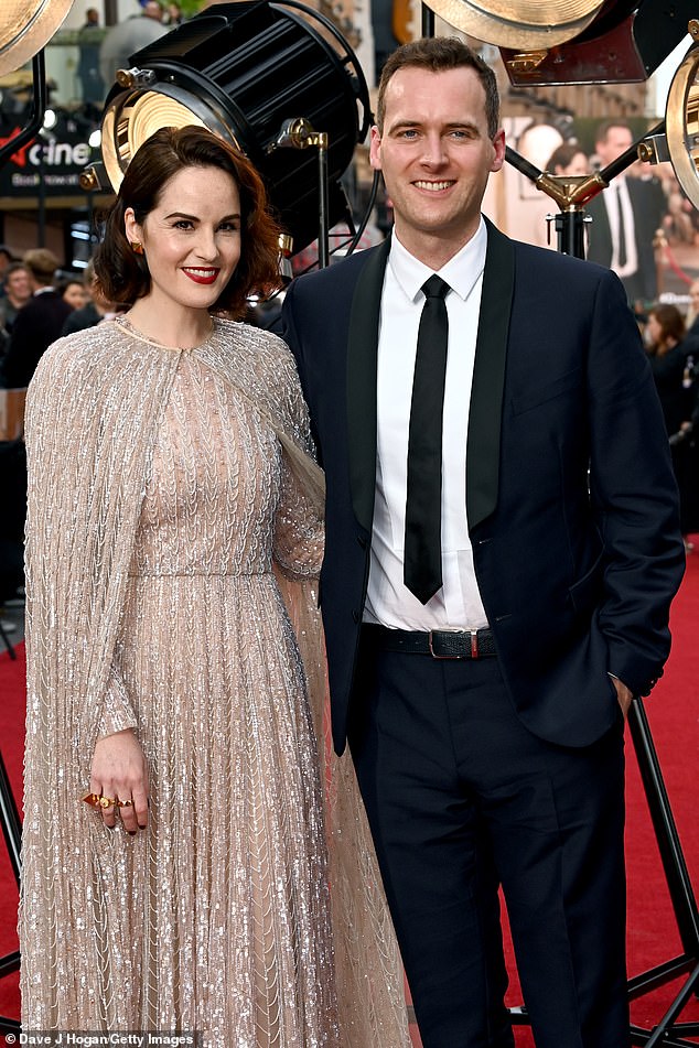Mendebarkan: Saat membuat debut karpet merahnya sebagai pasangan yang bertunangan, Michelle mengenakan gaun perak yang menarik perhatian di pemutaran perdana Downton Abbey: New Era London