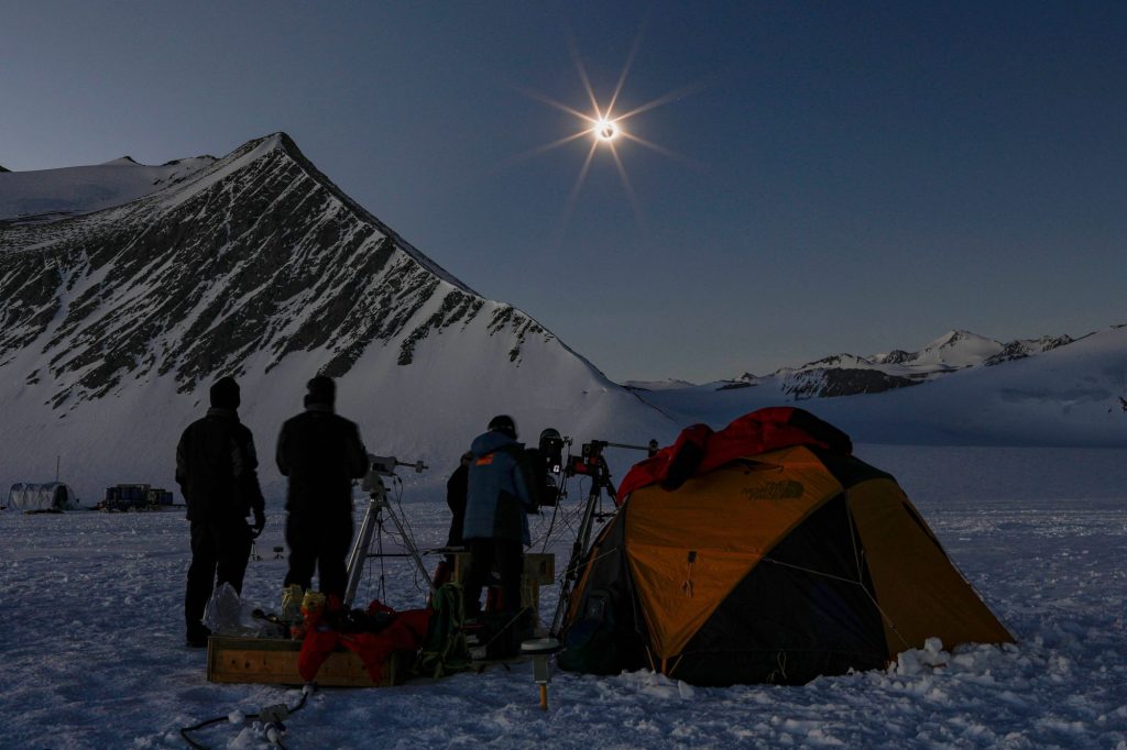 Gambar yang diposting oleh Imagen Chile ini menunjukkan para ilmuwan dari Chili dan Amerika Serikat melihat gerhana matahari dari Union Glacier di Antartika pada 4 Desember 2021.