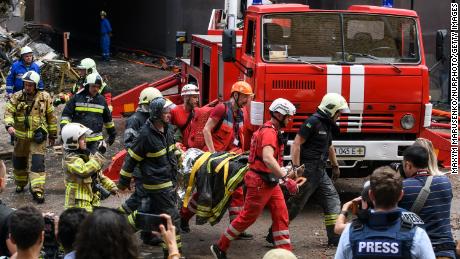 Petugas penyelamat mengevakuasi seseorang dari gedung apartemen yang hancur dalam serangan udara Rusia di distrik Shevchenkivsky di Kyiv pada 26 Juni 2022.