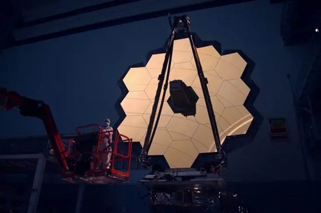 Cermin utama Teleskop Luar Angkasa James Webb menyala di kamar gelap