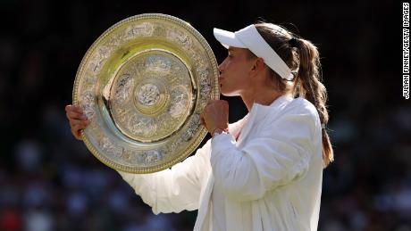 Rybakina menerima trofi yang memenangkan gelar tunggal putri di Wimbledon.