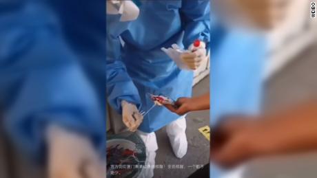 Petugas kesehatan di Xiamen memindai kepiting untuk mendeteksi Covid-19.