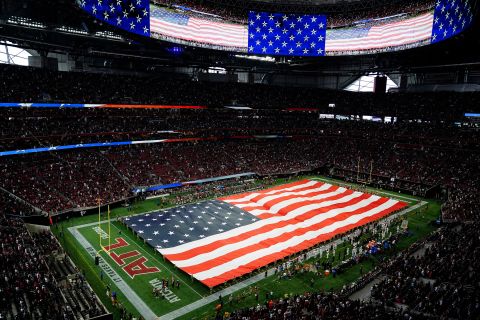 Tentara memegang bendera Amerika selama lagu kebangsaan sebelum paruh pertama pertandingan antara Atlanta Falcons dan New Orleans Saints pada 11 September di Atlanta.