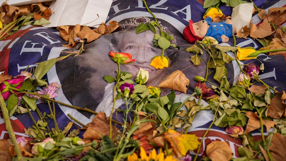 A flag carrying a portrait of Queen Elizabeth II is covered in flowers the day after her funeral, in London's Green Park, Tuesday, Sept. 20, 2022. The Queen, who died aged 96 on Sept. 8, was buried at Windsor alongside her late husband, Prince Philip
