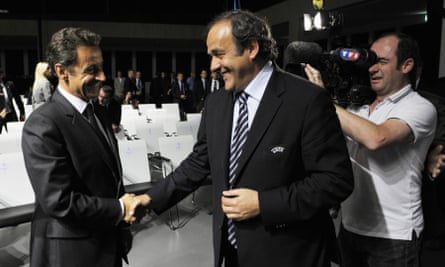 Michel Platini berjabat tangan dengan Nicolas Sarkozy (kiri) pada 2010.